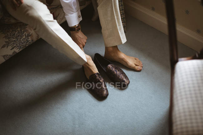 Vue rapprochée du marié portant des chaussures à la maison — Photo de stock
