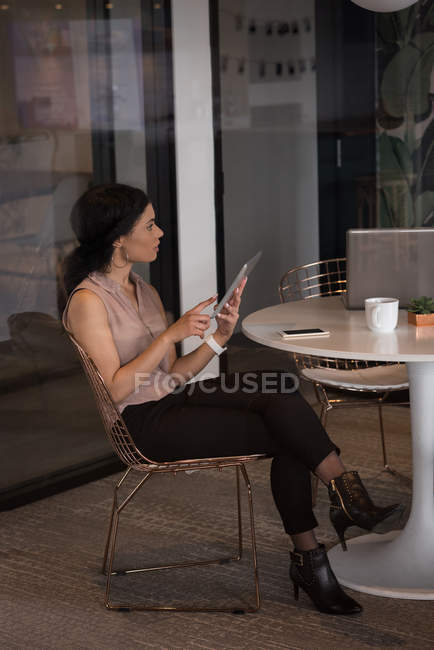 Керівник жіночого офісу використовує цифровий планшет у кафетерії в творчому офісі — стокове фото