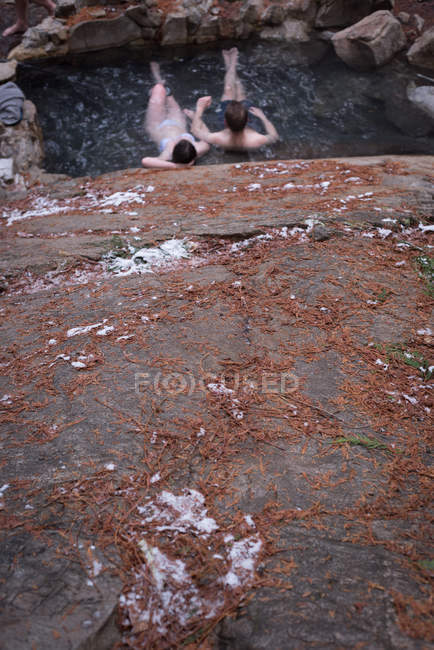 Couple relaxing in hot spring during winter — Stock Photo