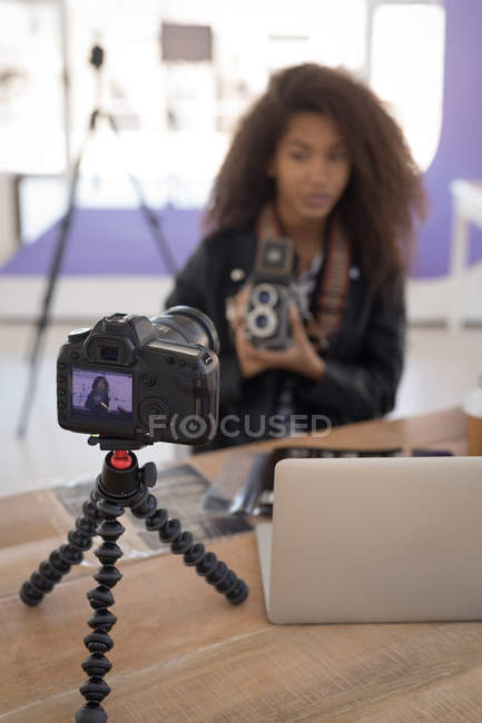 Pretty photographer working at laptop in studio — Stock Photo