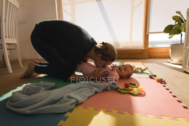 Mutter spielt mit Baby-Sohn zu Hause auf dem Boden. — Stockfoto