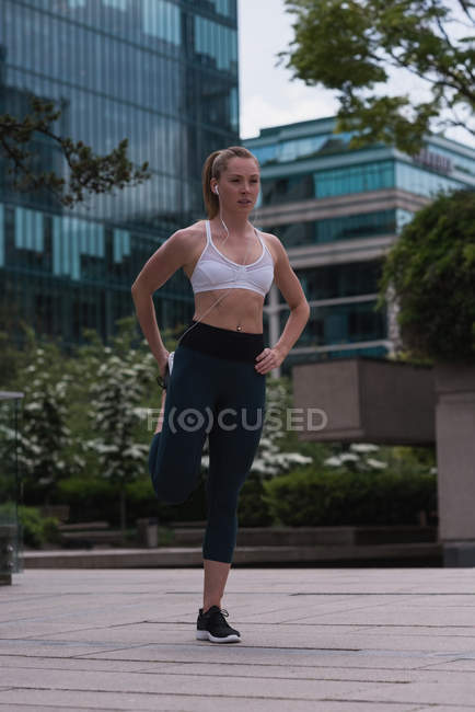 Young sporty woman stretching on street — Stock Photo