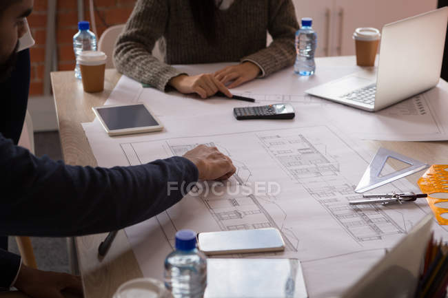 Бізнес-колеги обговорюють план в офісі — стокове фото