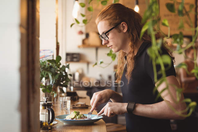 Side view of man having breakfast at table in cafe — Stock Photo