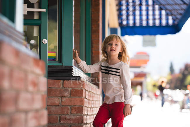 Портрет милой девушки, стоящей возле книжного магазина — стоковое фото