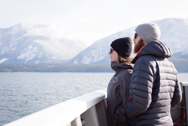 Paar blickt im Winter auf Fluss — Stockfoto