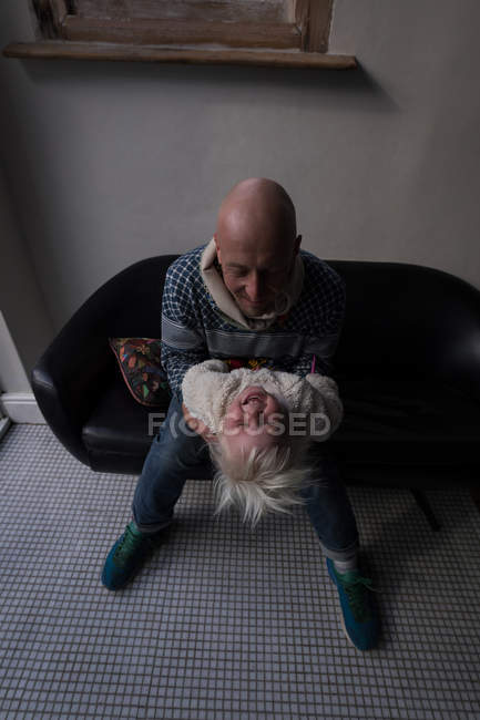 Vater spielt mit Tochter auf Sofa im heimischen Wohnzimmer. — Stockfoto
