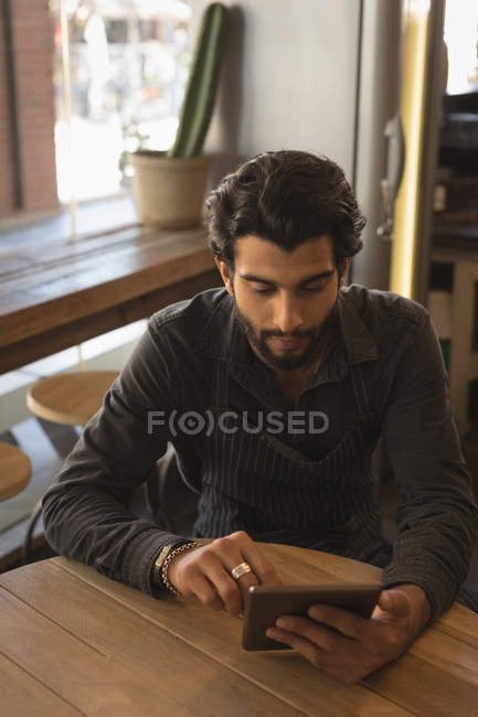 Homem usando tablet digital à mesa no café — Fotografia de Stock