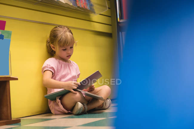 Невинная девушка читает книгу в магазине — стоковое фото