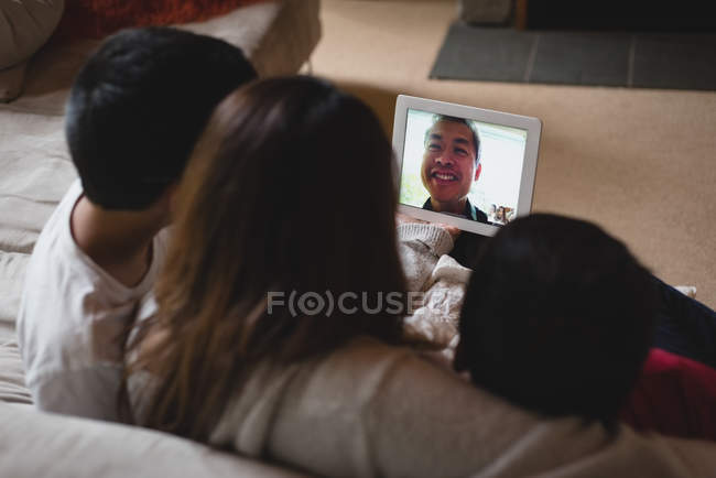 Mother and kids having video call on laptop in living room at home — Stock Photo