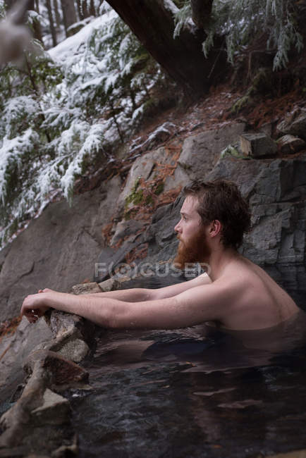 Homme réfléchi se détendre dans la source chaude pendant l'hiver — Photo de stock