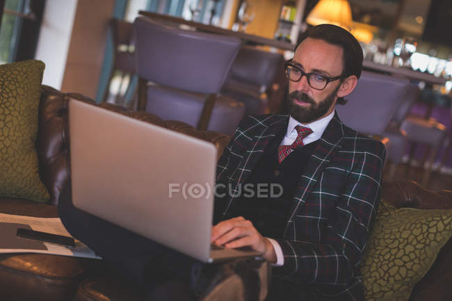 Geschäftsmann benutzt Laptop in Bar — Stockfoto