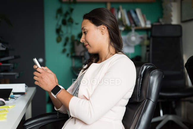 Weibliche Führungskraft mit Handy im Büro — Stockfoto