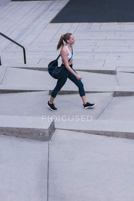 Jovem mulher esportiva andando na rua — Fotografia de Stock