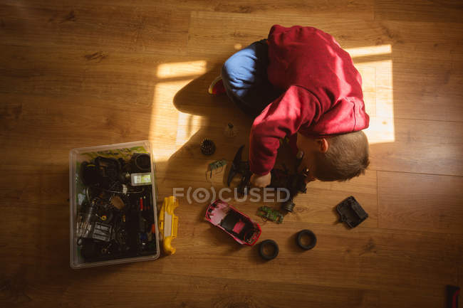 Menino reparando carro de brinquedo no quarto em casa — Fotografia de Stock