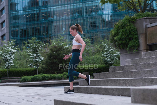 Jovem mulher esportiva correndo na rua — Fotografia de Stock