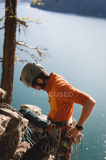 Hiker adjusting the carabiner with rope near lakesdie — Stock Photo