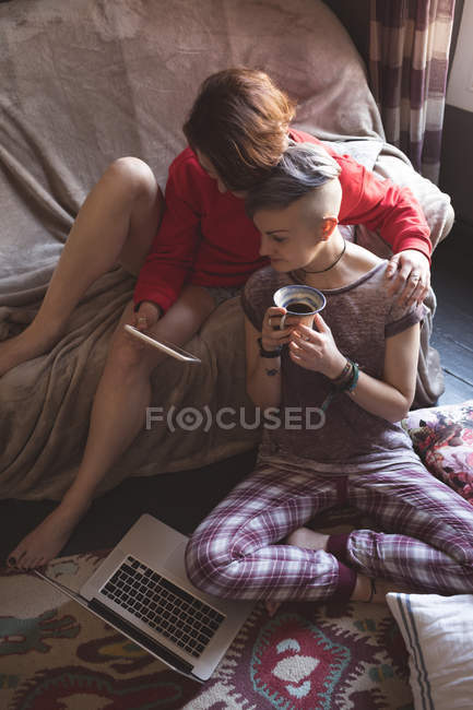 Лесбійську пару, використовуючи цифровий планшетний у вітальні на дому. — стокове фото