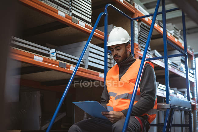 Lavoratore guardando appunti in fabbrica — Foto stock