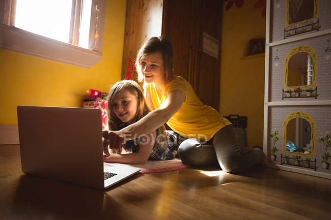 Mère et fille utilisant un ordinateur portable dans la chambre à coucher à la maison — Photo de stock
