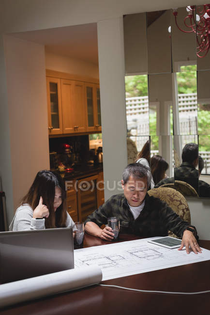 Couple looking at blueprint in home — Stock Photo