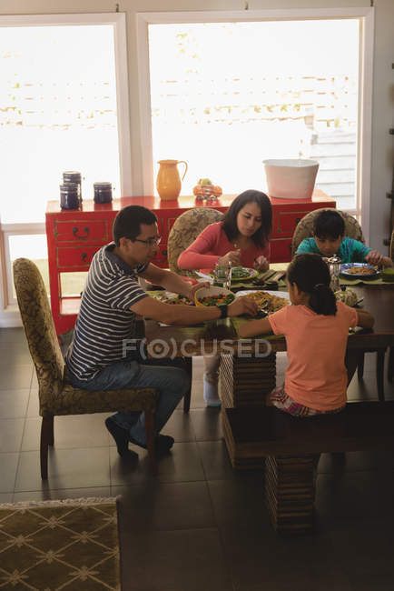 Família tomando café da manhã na mesa de jantar em casa — Fotografia de Stock
