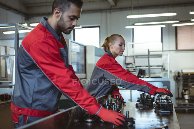 Dois trabalhadores verificando peças da máquina na fábrica — Fotografia de Stock
