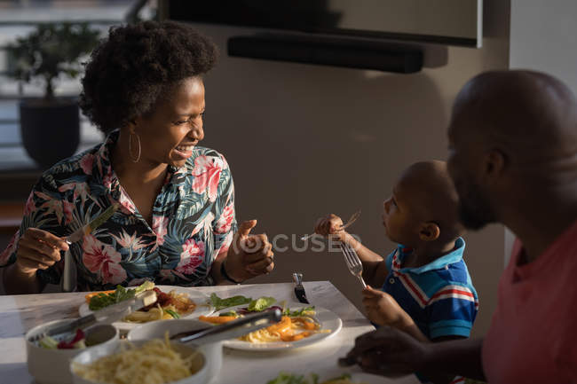 Familia con cena en la mesa en casa . - foto de stock
