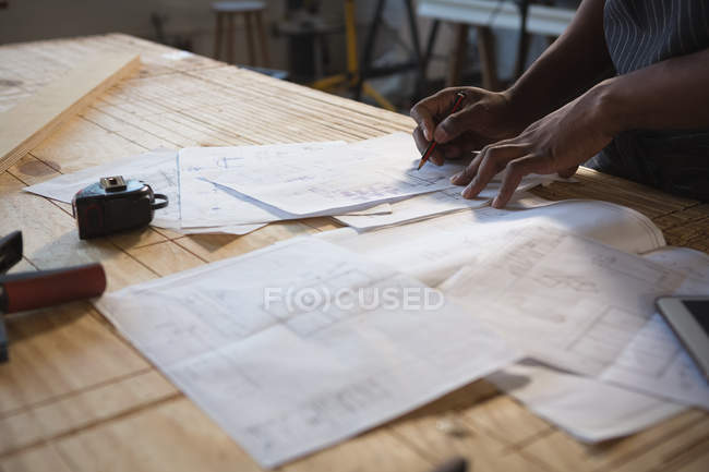 Seção média de carpinteiro trabalhando à mesa em oficina — Fotografia de Stock
