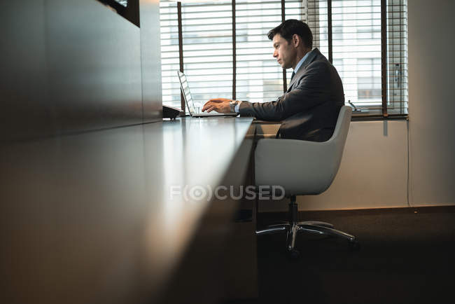 Бізнесмен, використовуючи ноутбук за столом в офісі — стокове фото