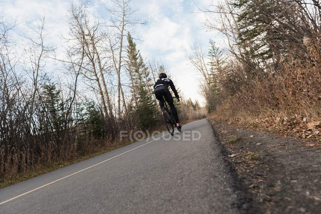 Байкер гірський велосипед їзда на дорозі у сонячний день — стокове фото