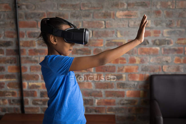 Menina pré-adolescente usando fone de ouvido realidade virtual no escritório . — Fotografia de Stock