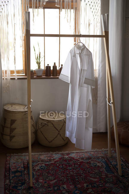 Cloth hanging on decorated rack in workshop — Stock Photo