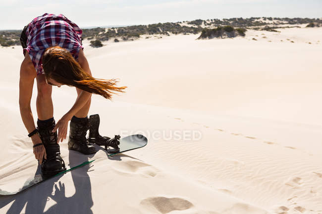 Frau trägt Sandbrett in Sanddüne an einem sonnigen Tag — Stockfoto