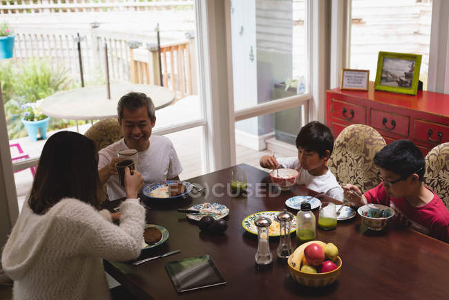 Семья завтракает на обеденном столе дома — стоковое фото