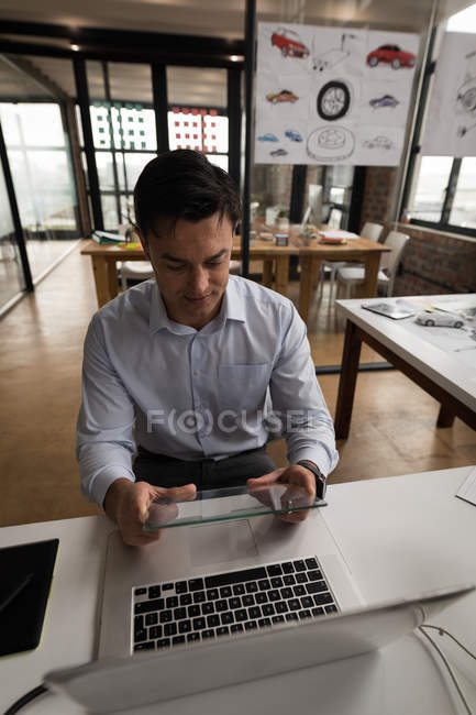 Бизнесмен использует стеклянный цифровой планшет на рабочем столе в офисе . — стоковое фото