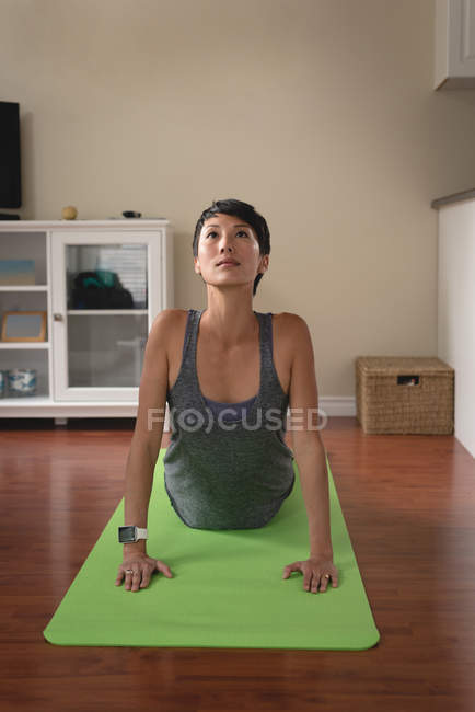 Mujer realizando yoga en salón en casa - foto de stock