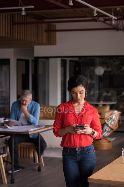 Beautiful office executive using mobile phone at creative office — Stock Photo