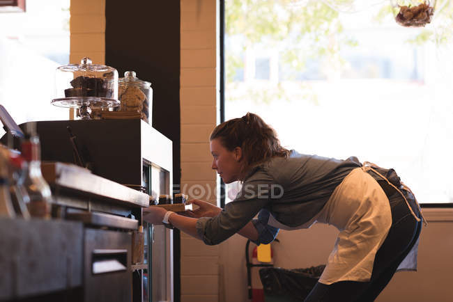 Beautiful waitress working at counter in cafe — Stock Photo
