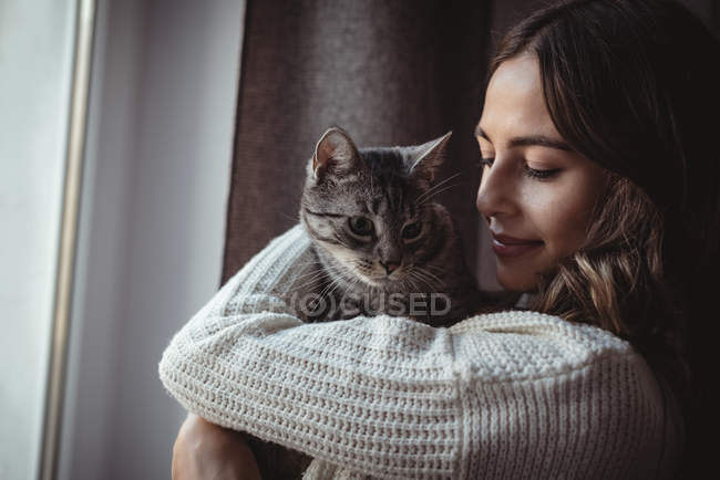 Close-up of beautiful woman embracing her pet cat — Stock Photo