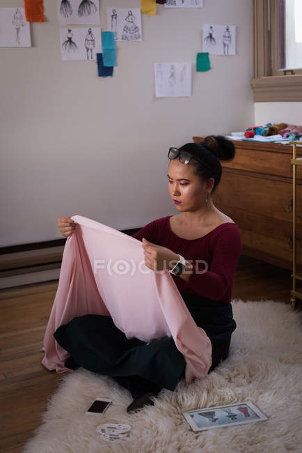 Fashion designer checking fabric in studio. — Stock Photo