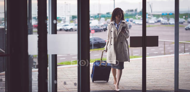 Gewandte Geschäftsfrau benutzt Handy bei Ankunft im Hotel — Stockfoto