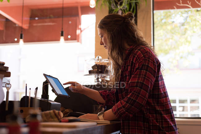 Proprietario femminile utilizzando tablet digitale al bancone in caffè — Foto stock