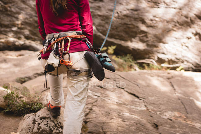Visão traseira da caminhante feminina se preparando para escalar a montanha rochosa — Fotografia de Stock