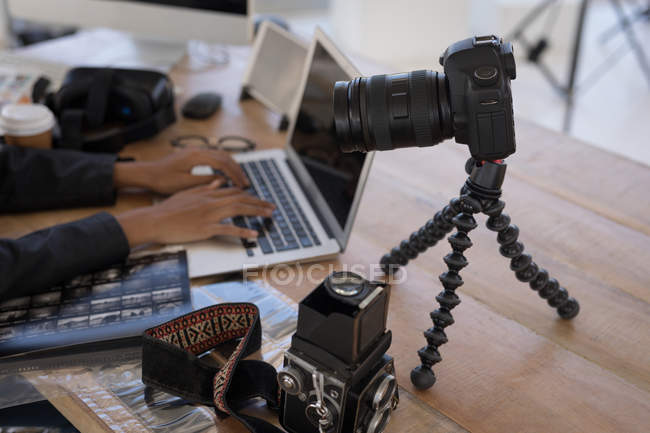 Photographer using laptop on desk in the photo studio — Stock Photo
