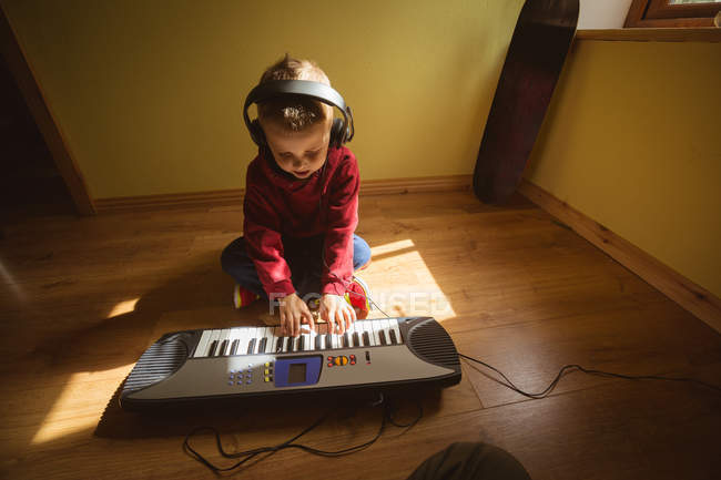 Маленький мальчик играет на пианино в спальне дома — стоковое фото
