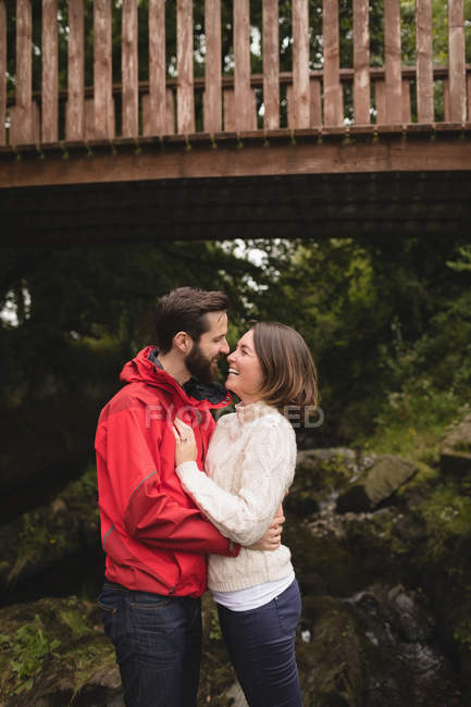Любящая пара, стоящая под мостом — стоковое фото