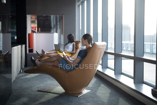 Ejecutiva femenina usando tableta digital en oficina futurista - foto de stock