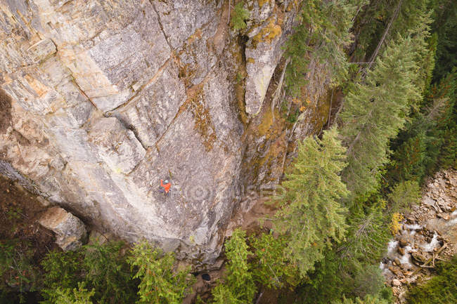 Высокий угол обзора определенного альпиниста, взбирающегося на скалистую скалу — стоковое фото
