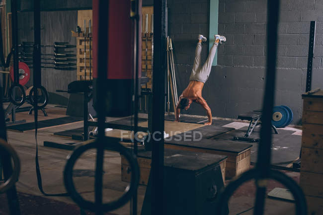 Homme musclé déterminé faisant de l'exercice dans le studio de fitness — Photo de stock